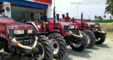 Showroom display of various Mahindra tractors with knowledgeable sales staff assisting customers
